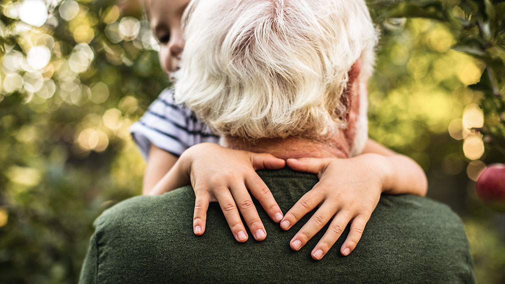 Mann in Rente spielt mit Enkelkind.