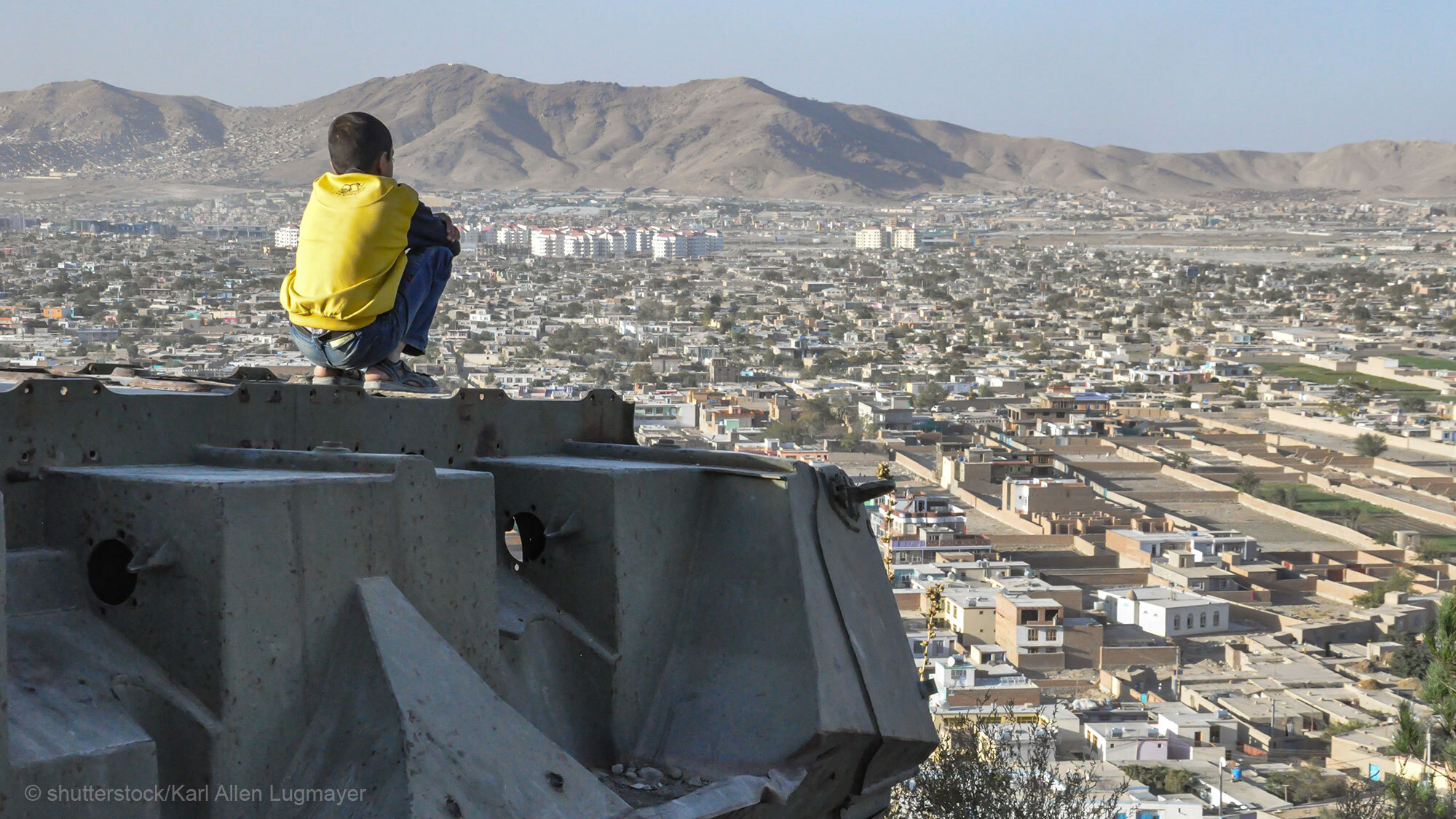 Afghanistan: Junge sitzt auf Panzer und schaut auf Kabul