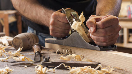 Handwerker verarbeitet Holz.