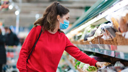 Frau mit Mundschutz beim Einkaufen.