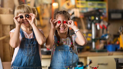 Zwei Mädchen halten sich Legoteile vor die Augen
