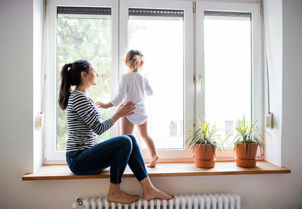 Mutter mit Kind auf Fensterbank