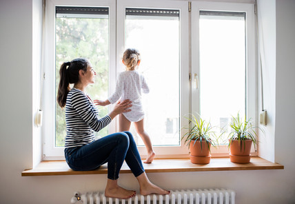 Mutter mit Kind auf Fensterbank