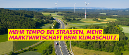 Autobahn führt durch Natur, grüne Wiesen, Windräder am Horizont, auf der Autobahn fahren Pkw und LKW. Text auf Bild: Mehr Tempo bei Straßen, mehr Marktwirtschaft beim Klimaschutz