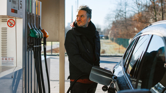 Ein Mann steht an einer Tankstelle 