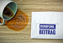 Kaffeebecher und Brief Rundfunkbeitrag
