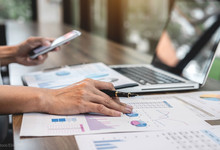 Finanzen, Laptop, Frau mit Smartphone