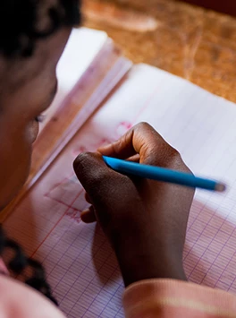Entwicklungspolitik: Mädchen schreibt in Notizbuch