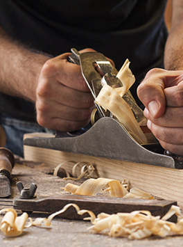 Handwerk: Mensch arbeitet an Werkbank mit Holz