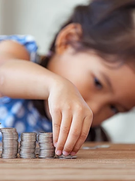 Finanzen: Mädchen baut Türme aus Geldmünzen
