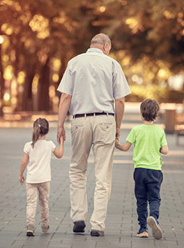 Rente: Großvater geht mit zwei Enkeln an der Hand