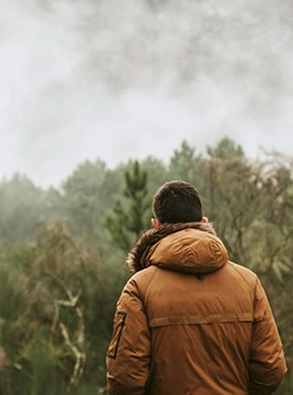 Klima: Mann steht in der Natur im Wald