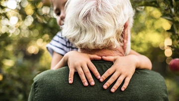 Mann in Rente spielt mit Enkelkind.