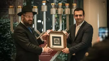 Rabbiner Yehuda Teichtal und FDP-Generalsekretär Bijan Djir-Sarai im Hans-Dietrich-Genscher-Haus vor dem Chanukka-Leuchter