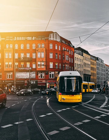 Bild von einer Kreuzung mit Autos, Straßenbahn, Fußgängern und Radfahrern, Text auf Bild: Pendlerpauschale erhalten. Keine Mehrbelastung für die arbeitende Mitte
